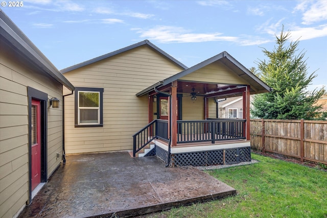 rear view of house featuring a patio area, fence, a lawn, and ceiling fan