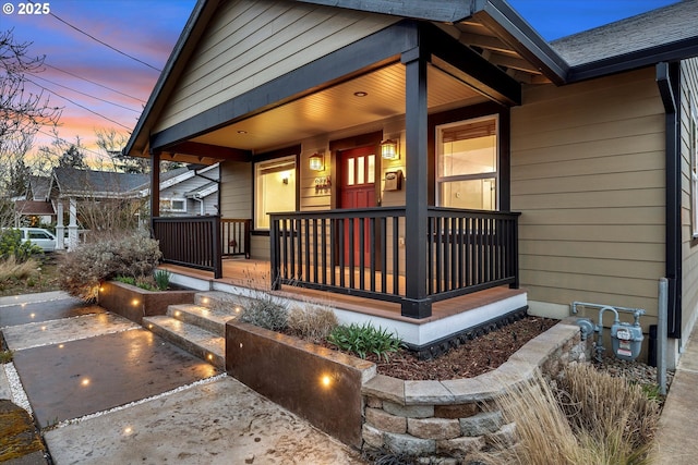 exterior entry at dusk featuring a porch