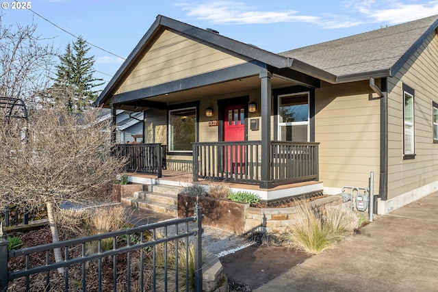 bungalow with covered porch and a shingled roof