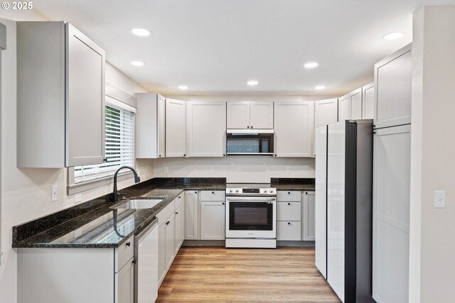 kitchen with sink, white refrigerator, dishwasher, electric stove, and white cabinets