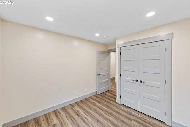 unfurnished bedroom featuring light hardwood / wood-style floors and a closet