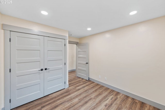 unfurnished bedroom with light hardwood / wood-style floors and a closet