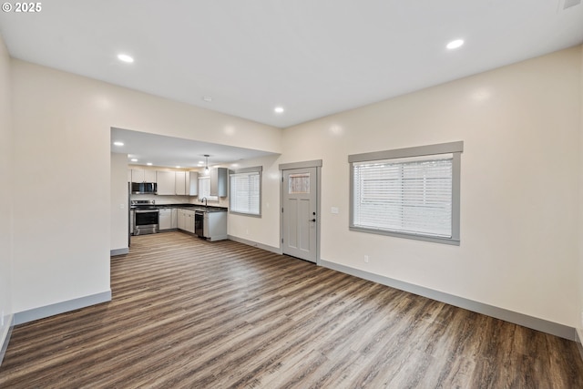 unfurnished living room with hardwood / wood-style flooring and sink