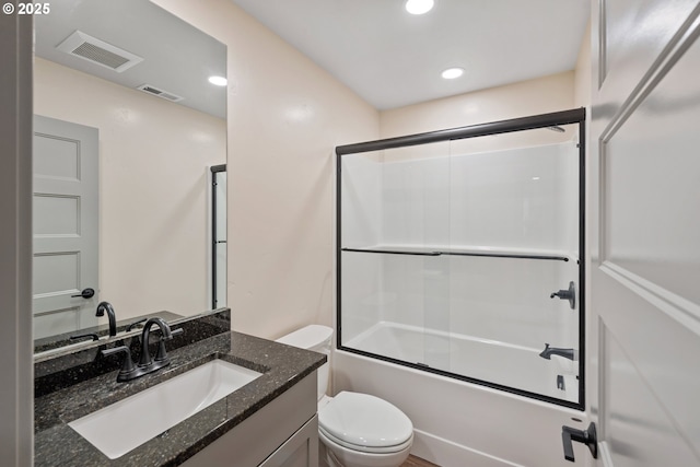 full bathroom with vanity, bath / shower combo with glass door, and toilet