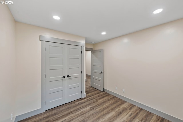 unfurnished bedroom featuring wood-type flooring and a closet