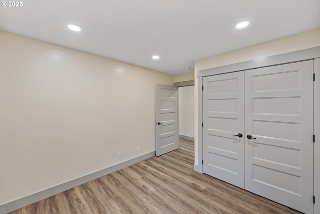 unfurnished bedroom featuring a closet and light wood-type flooring