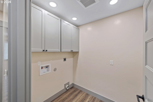 laundry room featuring cabinets, hookup for a washing machine, dark wood-type flooring, and hookup for an electric dryer