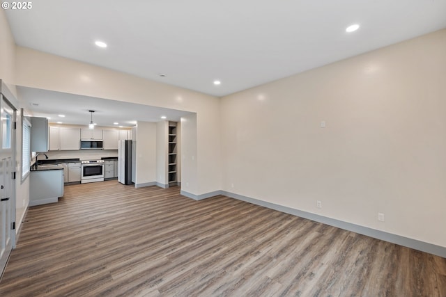 unfurnished living room with sink and light hardwood / wood-style flooring