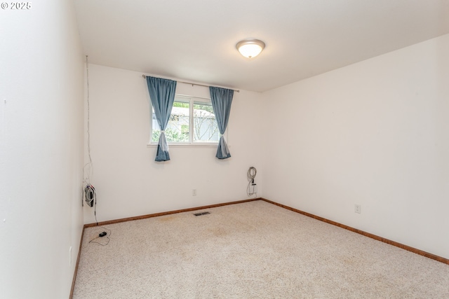 empty room with visible vents, carpet, and baseboards