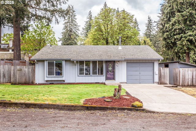 ranch-style house featuring an attached garage, fence, driveway, and a front yard