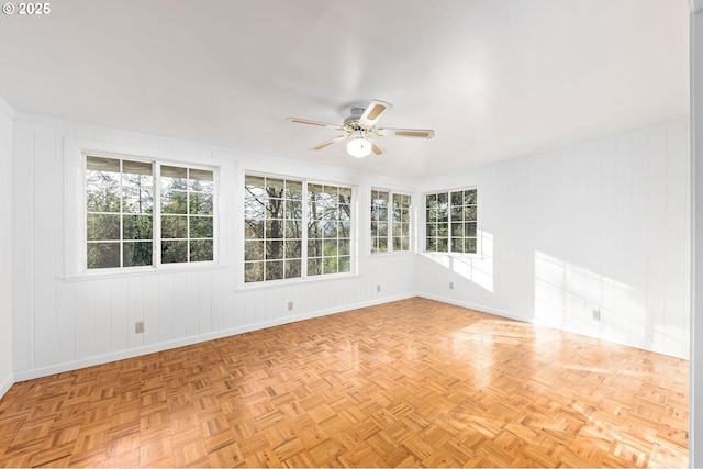 spare room featuring a ceiling fan and baseboards