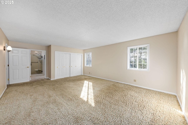 unfurnished bedroom featuring carpet floors, a textured ceiling, baseboards, and a closet