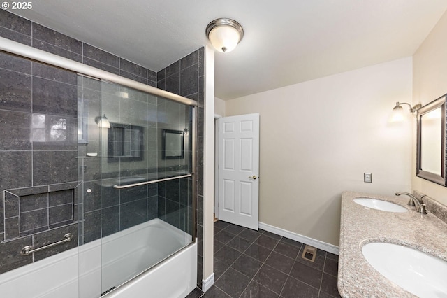 bathroom with tile patterned flooring, enclosed tub / shower combo, baseboards, and a sink