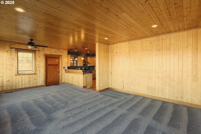 371 Summit Ridge Dr, The Dalles, OR 97058 - unfurnished living room featuring wood ceiling, dark carpet, a ceiling fan, wood walls, and baseboards