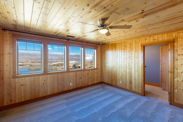 carpeted empty room with ceiling fan, visible vents, wood ceiling, and baseboards