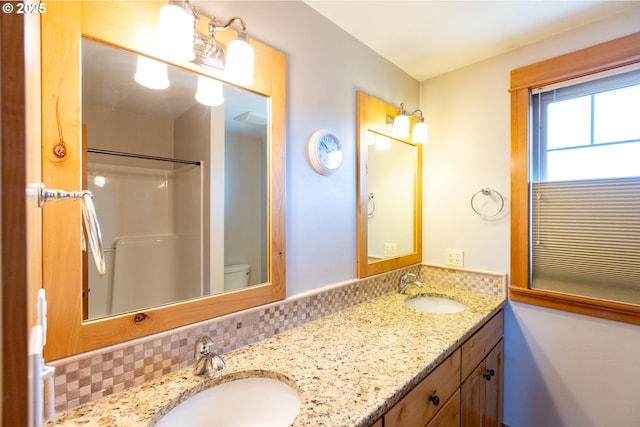 bathroom featuring double vanity, decorative backsplash, and a sink