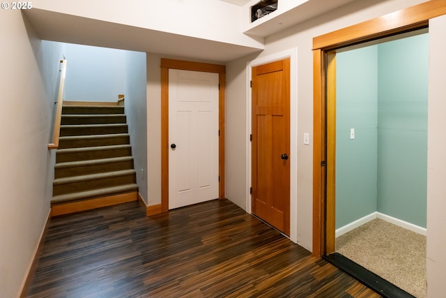 hallway featuring dark wood-style floors, baseboards, and stairs