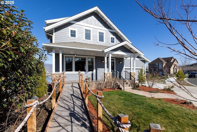 view of front of house with covered porch, board and batten siding, and a front yard