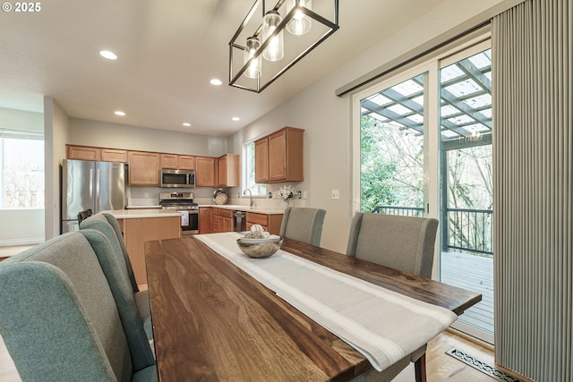 dining room with a healthy amount of sunlight, sink, and light hardwood / wood-style flooring