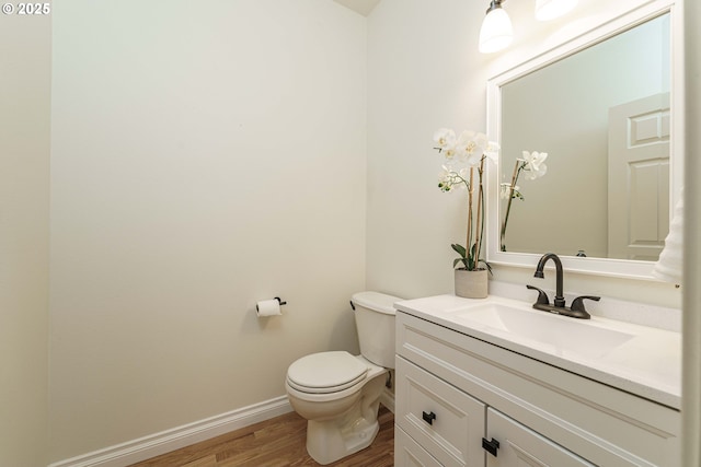 bathroom featuring vanity, hardwood / wood-style floors, and toilet