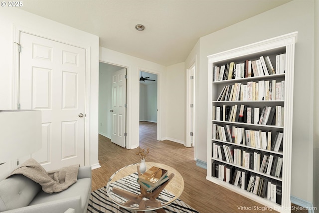 living area with built in features and light hardwood / wood-style flooring