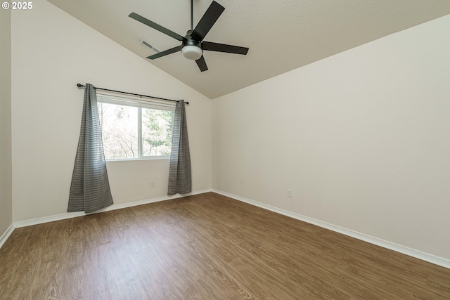 spare room with wood-type flooring, ceiling fan, and vaulted ceiling