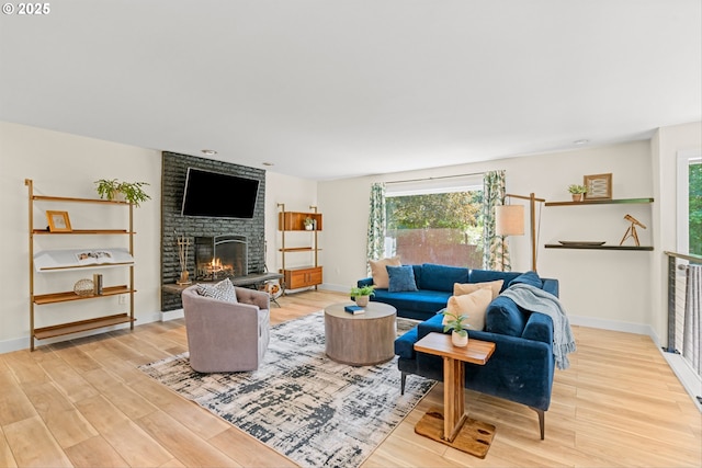 5017 SW Fairvale Ct, Portland, OR 97221 - living area with light wood-style flooring, healthy amount of natural light, a brick fireplace, and baseboards