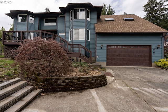 view of front of property featuring an attached garage, stairs, roof with shingles, and driveway