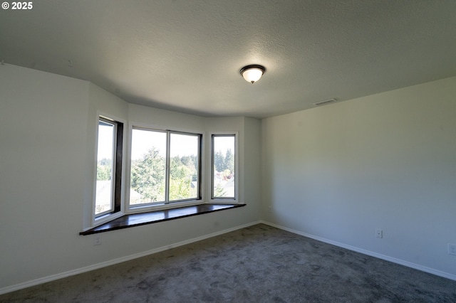 carpeted empty room with visible vents, a textured ceiling, and baseboards