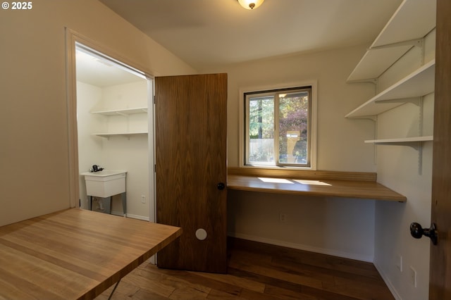 unfurnished office with baseboards and wood finished floors