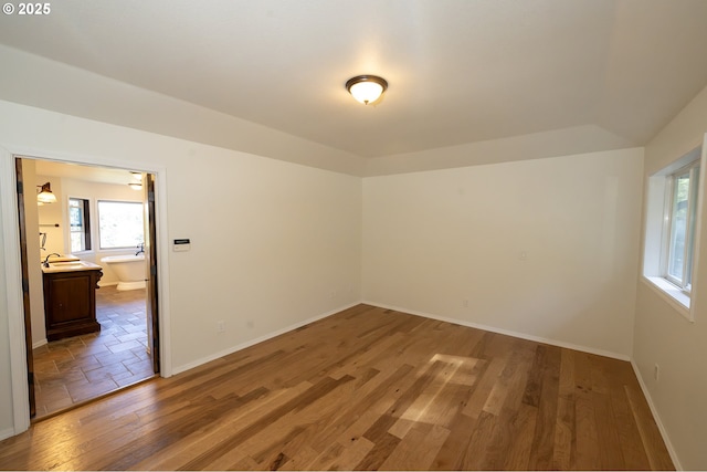 unfurnished room featuring baseboards and wood finished floors