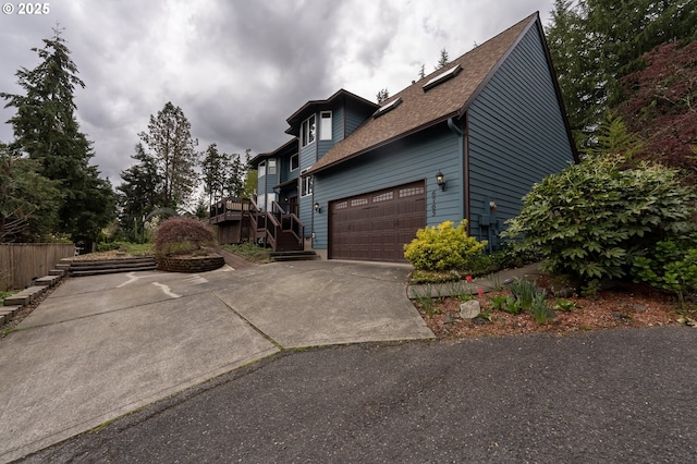 6765 SW 153rd Ave, Beaverton, OR 97007 - view of property exterior with concrete driveway, roof with shingles, a garage, and stairs