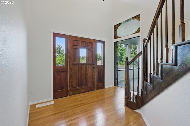 6765 SW 153rd Ave, Beaverton, OR 97007 - entrance foyer featuring stairs, light wood finished floors, baseboards, and a towering ceiling