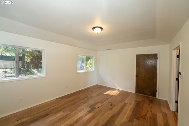 unfurnished room with baseboards and wood finished floors