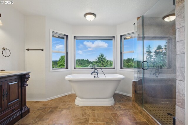 6765 SW 153rd Ave, Beaverton, OR 97007 - full bath with vanity, a shower stall, a freestanding tub, stone finish flooring, and baseboards