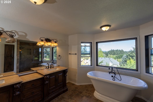 full bathroom with a tile shower, a textured ceiling, baseboards, a soaking tub, and stone tile flooring