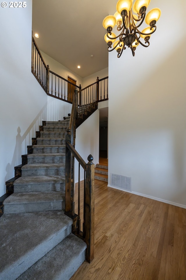 6765 SW 153rd Ave, Beaverton, OR 97007 - stairway with wood finished floors, a chandelier, recessed lighting, and baseboards