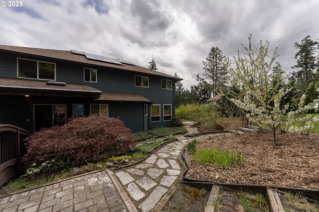 rear view of property with roof mounted solar panels