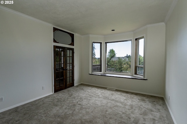 spare room with french doors, visible vents, crown molding, baseboards, and carpet flooring