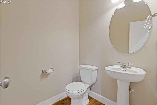 bathroom with wood-type flooring and toilet