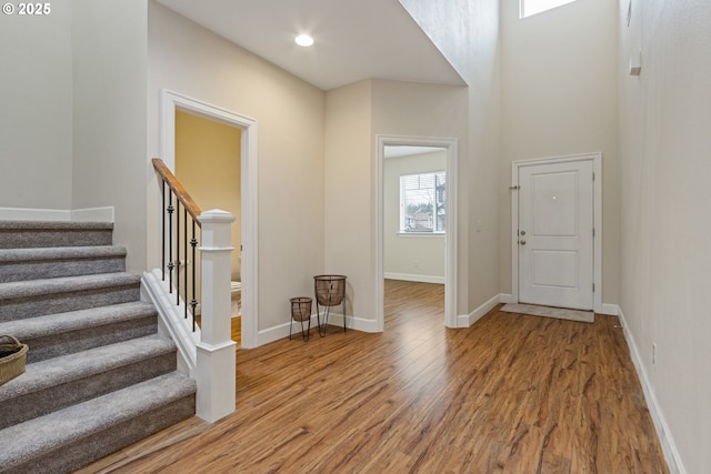 foyer entrance featuring wood-type flooring and a high ceiling