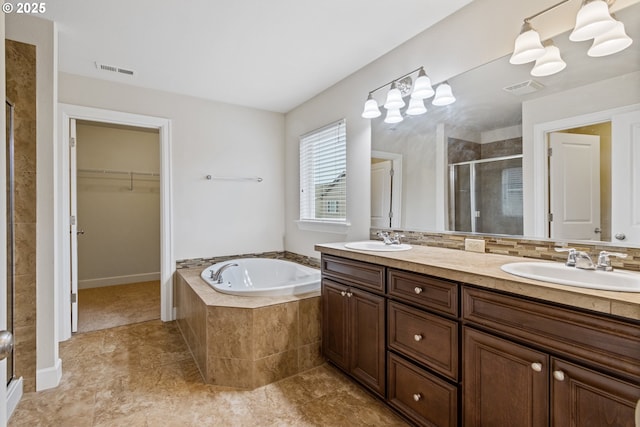 bathroom with vanity and shower with separate bathtub