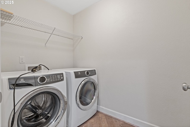 washroom with washer and clothes dryer and light hardwood / wood-style floors