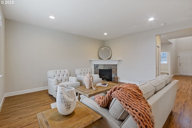 living room featuring hardwood / wood-style flooring and a tiled fireplace