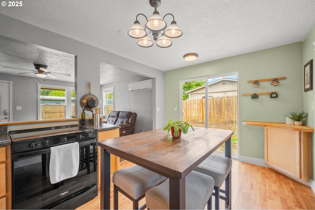 2115 NE 86th Ave, Vancouver, WA 98664 - dining space featuring a textured ceiling, an AC wall unit, a chandelier, light wood-style floors, and baseboards