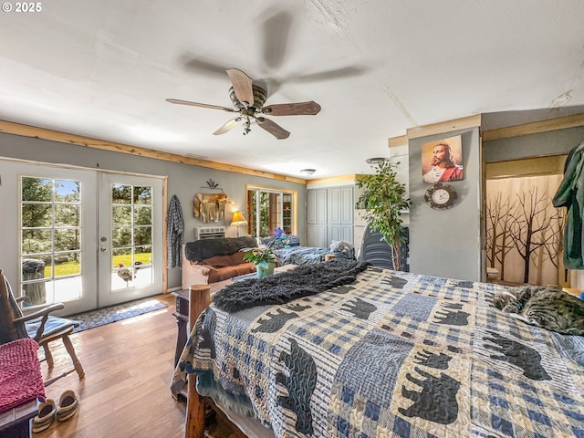 bedroom featuring access to exterior, french doors, wood finished floors, and ceiling fan