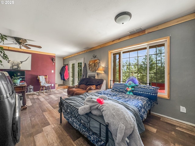 bedroom featuring wood finished floors, multiple windows, and baseboards