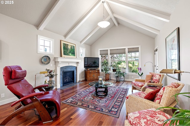living area featuring high vaulted ceiling, baseboards, a fireplace with flush hearth, wood finished floors, and beamed ceiling