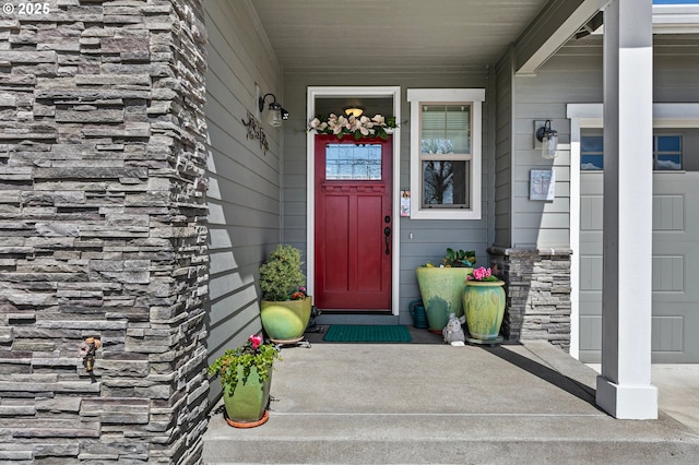 entrance to property featuring covered porch and stone siding