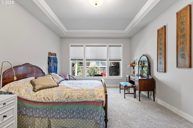 bedroom featuring carpet floors, a tray ceiling, crown molding, and baseboards